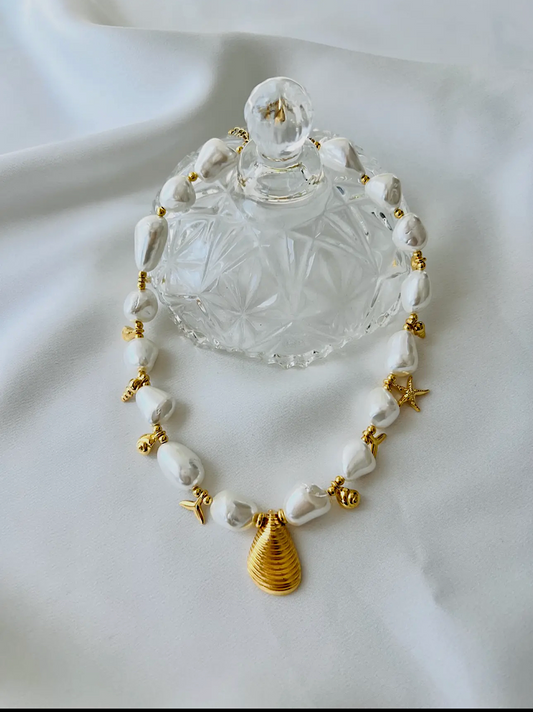 Necklace with white beads and gold accents on a white background